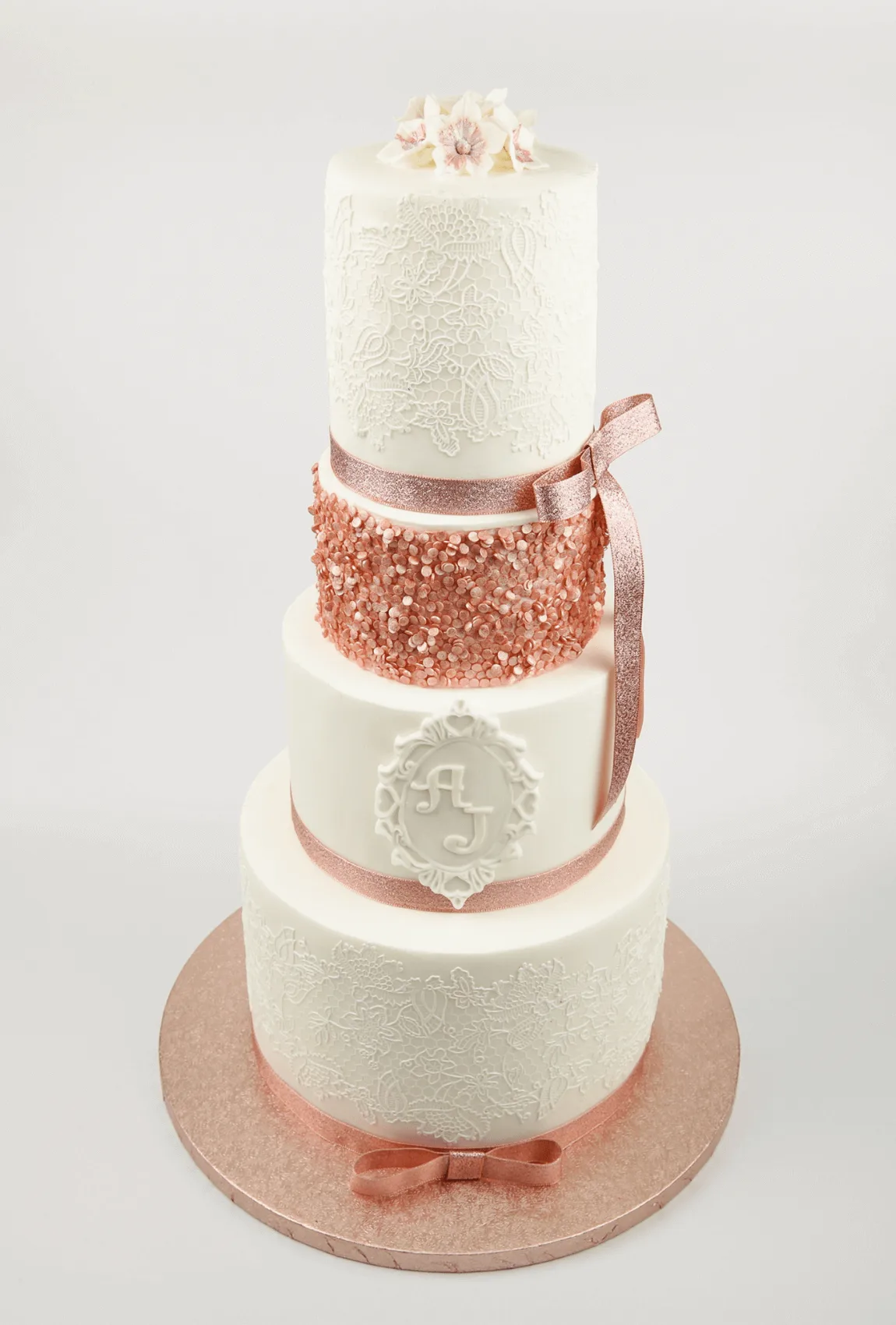 Elegant white bespoke wedding cake with floral details by Anne Robinson, a luxury cake designer in Cambridgeshire – Wedding Cake Design 24