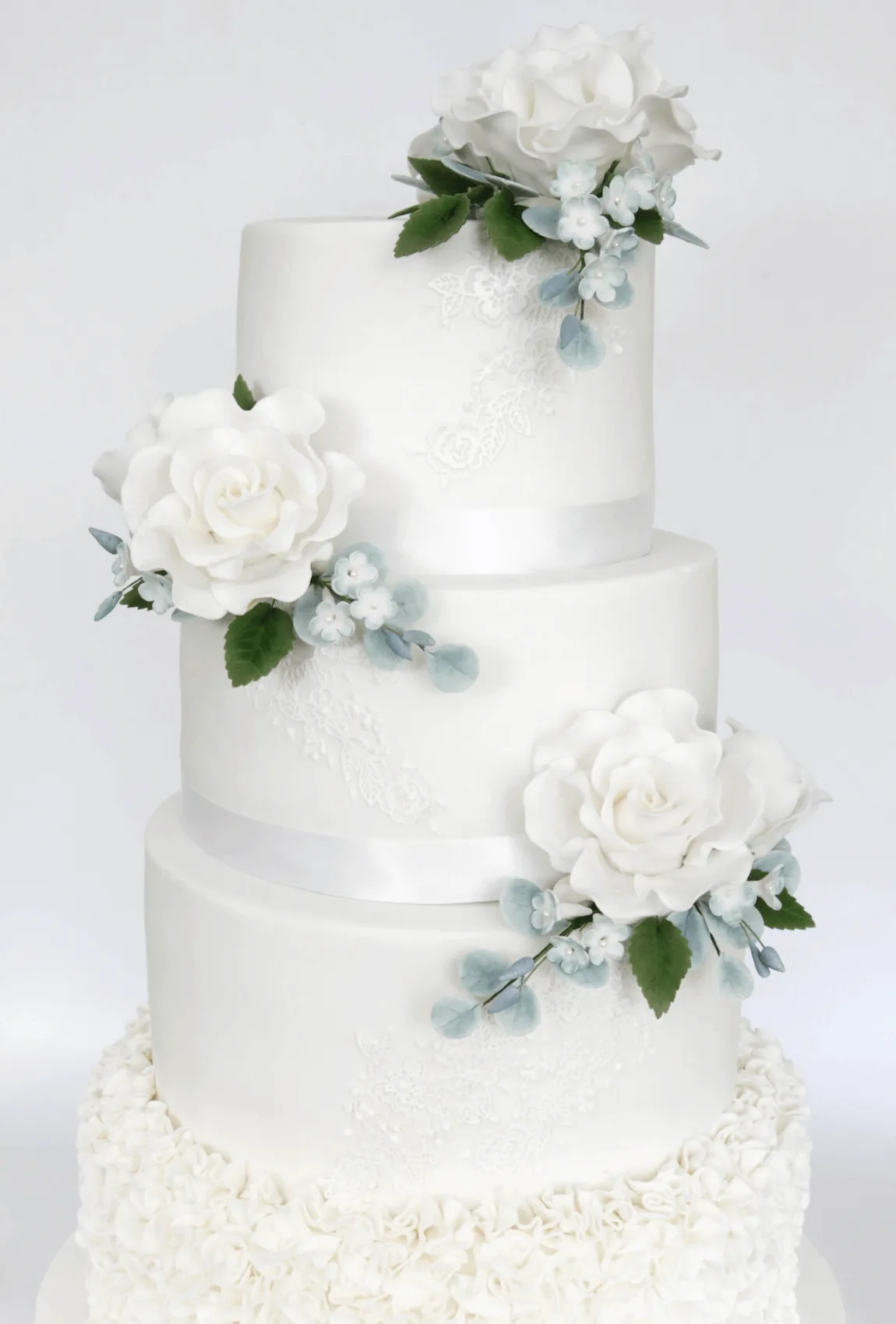 Elegant white bespoke wedding cake with floral details by Anne Robinson, a luxury cake designer in Cambridgeshire – Wedding Cake Design 15