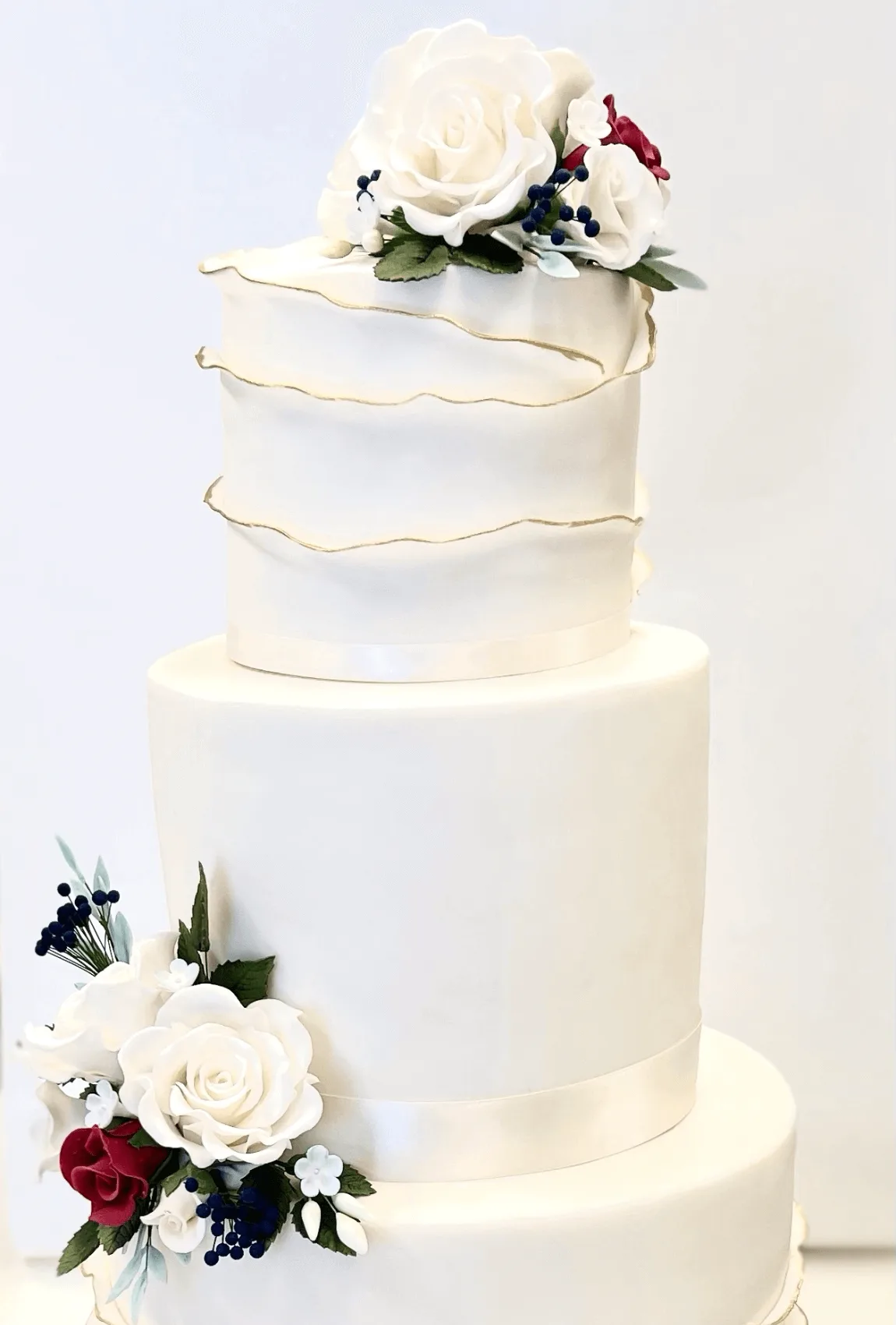 Elegant white bespoke wedding cake with floral details by Anne Robinson, a luxury cake designer in Cambridgeshire – Wedding Cake Design 29
